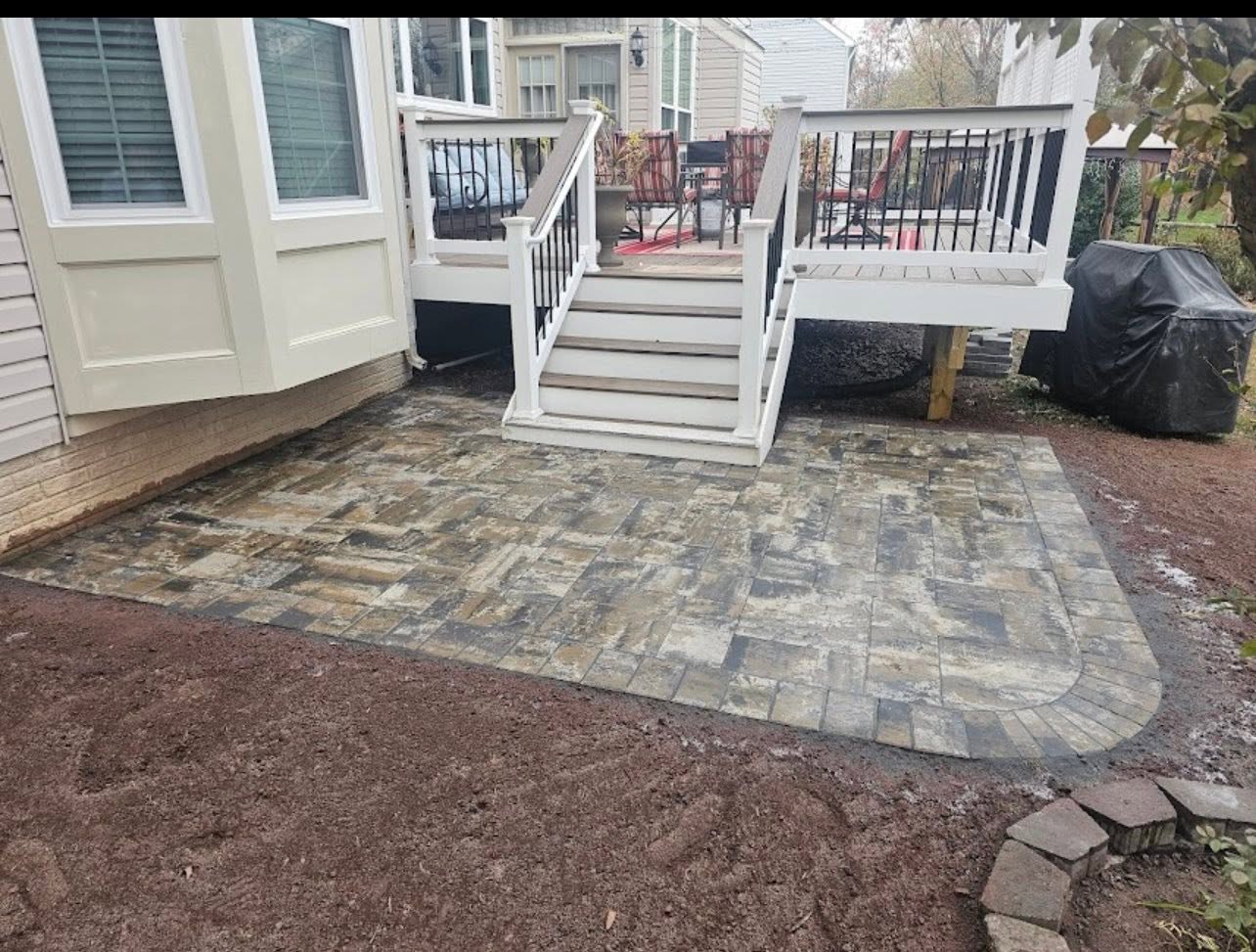 Paver patio joining a raised deck and stairs