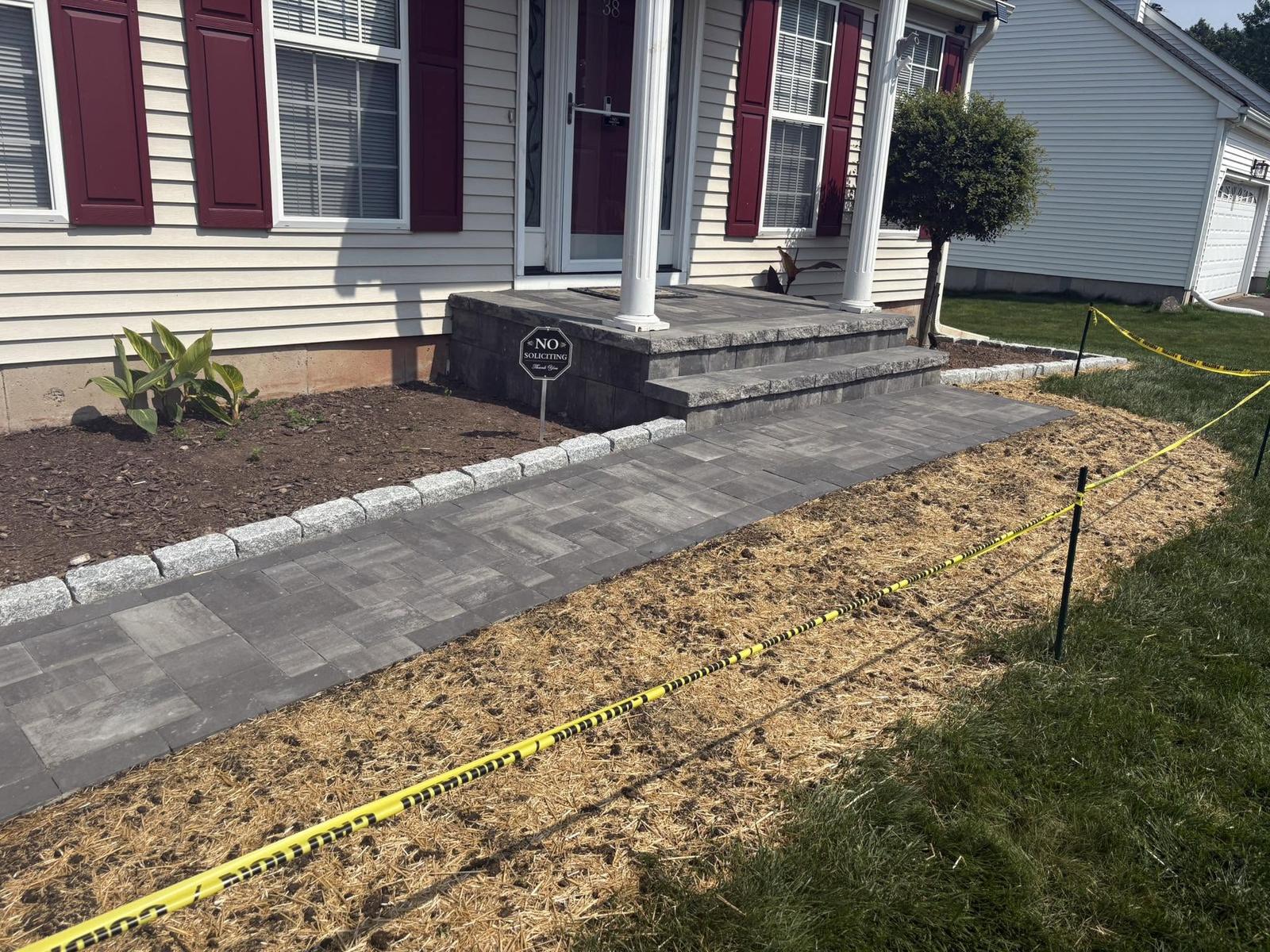 Paver steps and walkway with a granite cobble border built by GA Paving & Masonry
